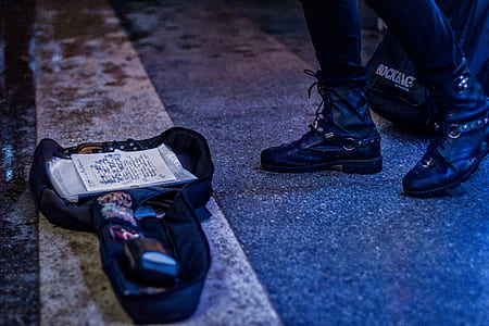person wearing black boots standing near bag thumbnail