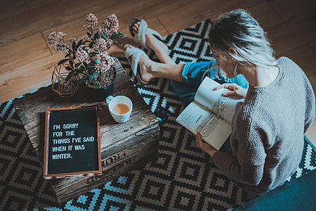 woman reading book near coffee table thumbnail