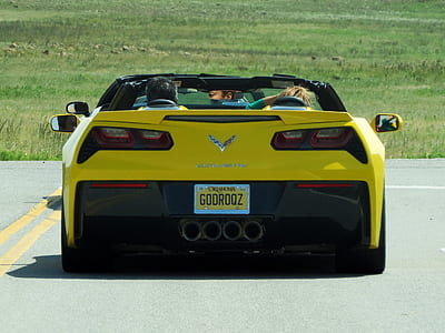 man and woman on yellow Chevrolet Corvette thumbnail