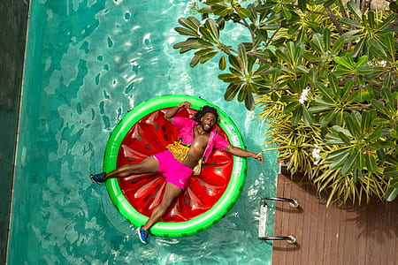 man riding on red and green floating buoy thumbnail
