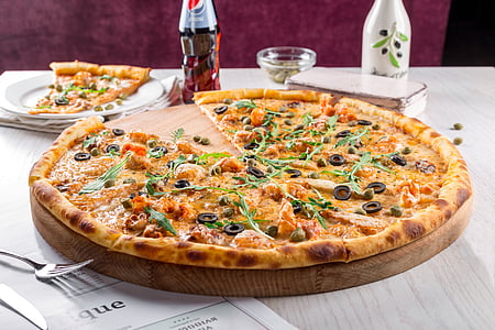 baked olive pizza on table thumbnail