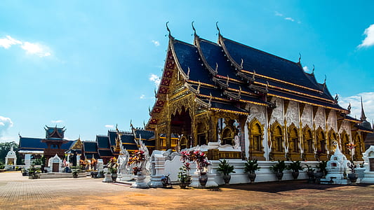 gold and blue temple with figurine under clear blue sky thumbnail