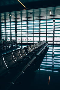 low light photography of gang chairs beside hangar thumbnail