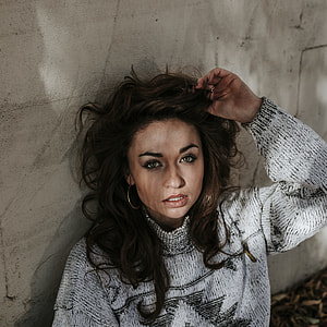 woman leaning on white wall thumbnail