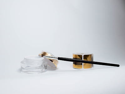 black makeup brush on clear cream jar thumbnail