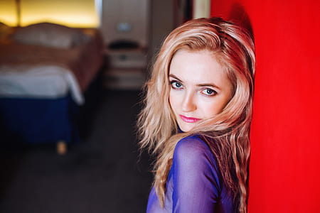 woman leaning against wall while taking selfie indoors thumbnail