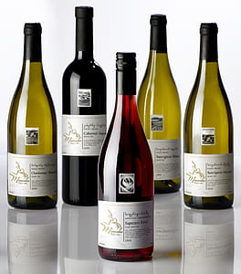 five labeled bottles placed on white surface thumbnail
