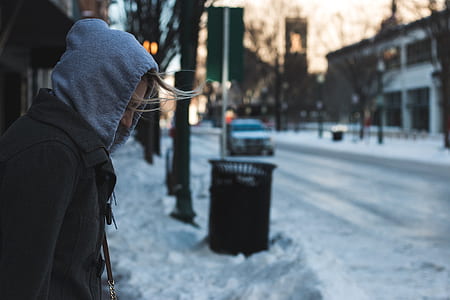 selective focus photography of person wearing hoodie near road thumbnail