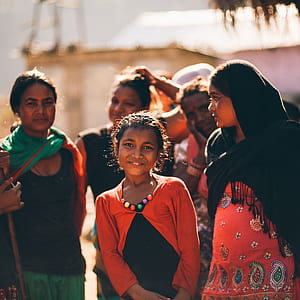 selective focus photography of girl surrounded with woman while smiling thumbnail