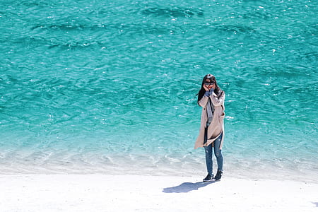 woman standing on seashore at daytime thumbnail