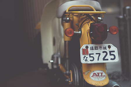 selective focus photo of yellow and white motor scooter thumbnail