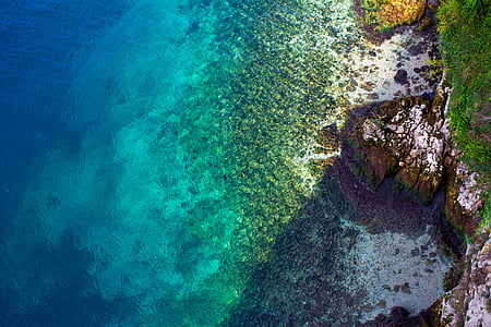 aerial photography of coral reef near cliff thumbnail