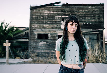 woman standing against old brown building thumbnail