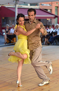 man wearing brown long sleeve shirt while dancing woman wearing yellow halter dress thumbnail