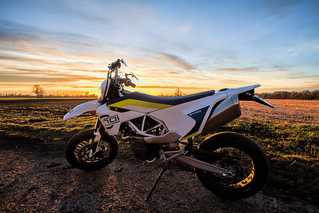 white Husqvarnia dirt bike parked near grass during thumbnail