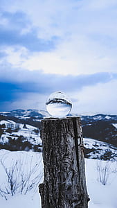 clear glass ball with glacier mountain on stomp at daytime thumbnail