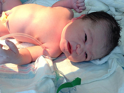 newborn infant on white blanket thumbnail