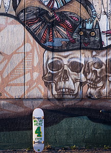 white and green skateboard on painted concrete wall at daytime thumbnail