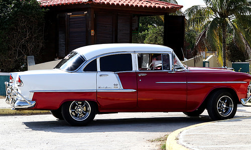 blue and white sedan parked on road thumbnail