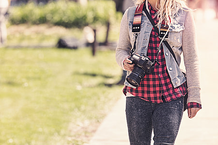 selective focus photo of woman holding DSLR camera thumbnail