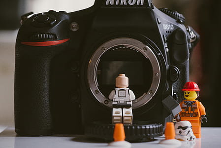 mini lego figures standing near canon camera thumbnail