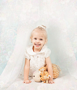 girl in white lace puff-sleeved dress smiling for photo thumbnail