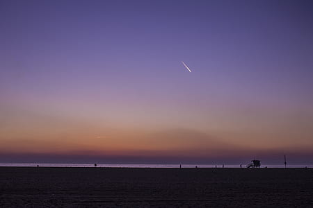 silhouette of bay near body of water at dawn thumbnail