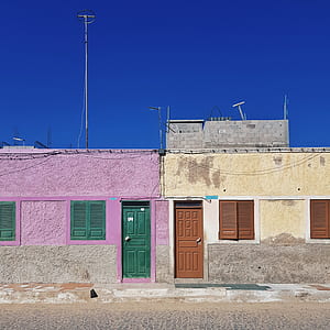 purple and beige painted concrete house under blue sky thumbnail