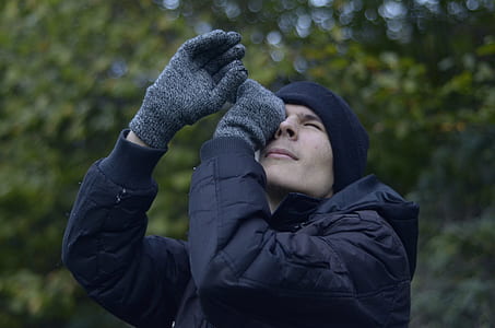 man wearing bubble jacket sighting upward thumbnail