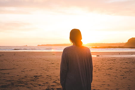 woman looking at sun during golden hour thumbnail