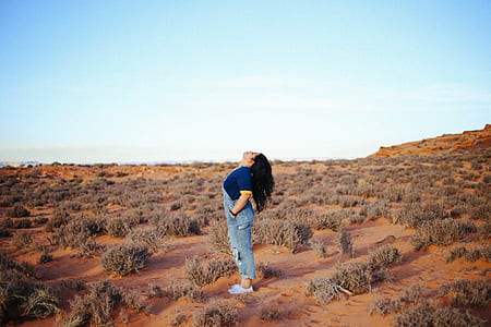 woman standing on sand beside grass thumbnail