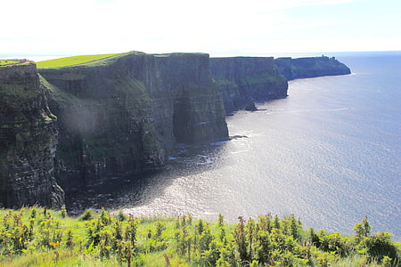 aerial photography of green mountain near body of water thumbnail