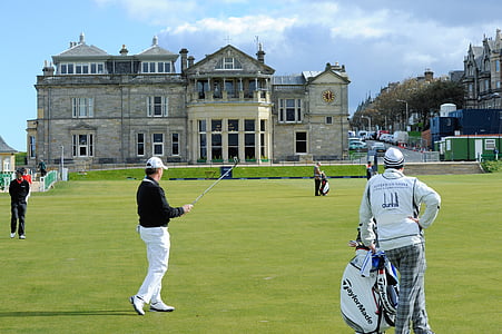 men playing golf near gray concrete building thumbnail