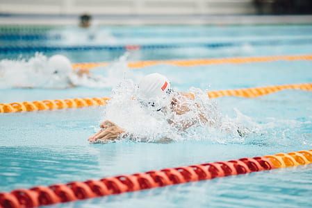 selective focus photography of person swimming in pool thumbnail