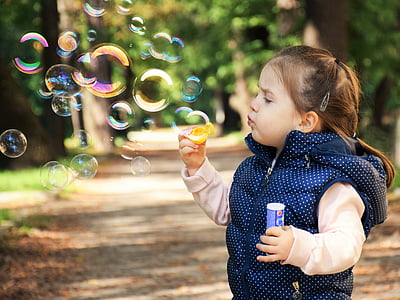 selective focus photography of girl blowing bubbles thumbnail
