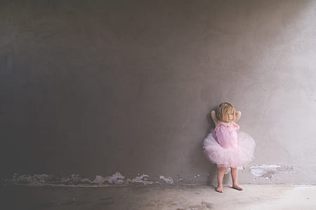 toddler's wearing pink tutu dress leaning on wall thumbnail