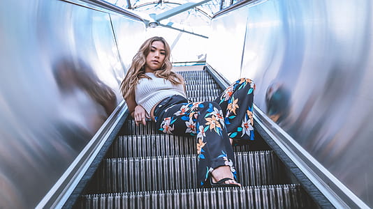 woman sitting on escalator while taking selfie thumbnail