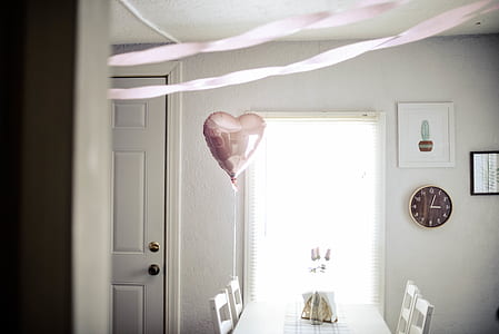 white table with chairs and pink balloon in front of window thumbnail
