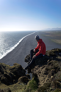 man sitting of brown mount cliff thumbnail