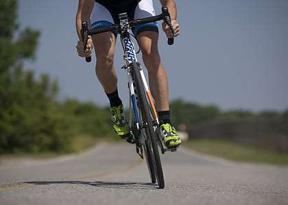 man cycling on road during daytime thumbnail