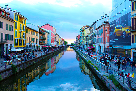 green body of water between buildings under blue sky thumbnail