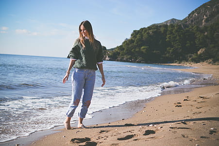 woman standing on seashore background of mountain view thumbnail