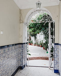 white metal gate near field of leafed plants thumbnail
