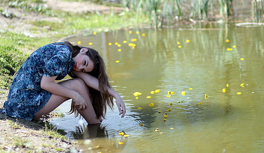 woman seating near body of water thumbnail