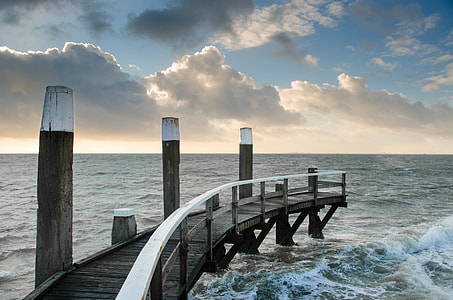 waves splashing trough the brown wooden dock thumbnail