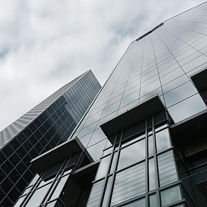 bottom view of high rise building under cloudy sky thumbnail