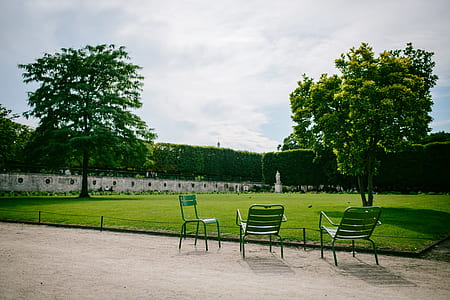 three chairs on pathway near trees thumbnail