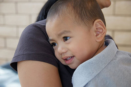 woman carrying child during dayrime thumbnail