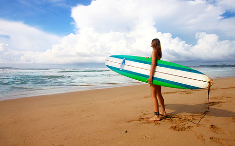 woman holding green and white surfboard thumbnail
