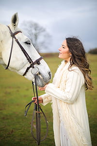 woman holding horse under blue sky thumbnail